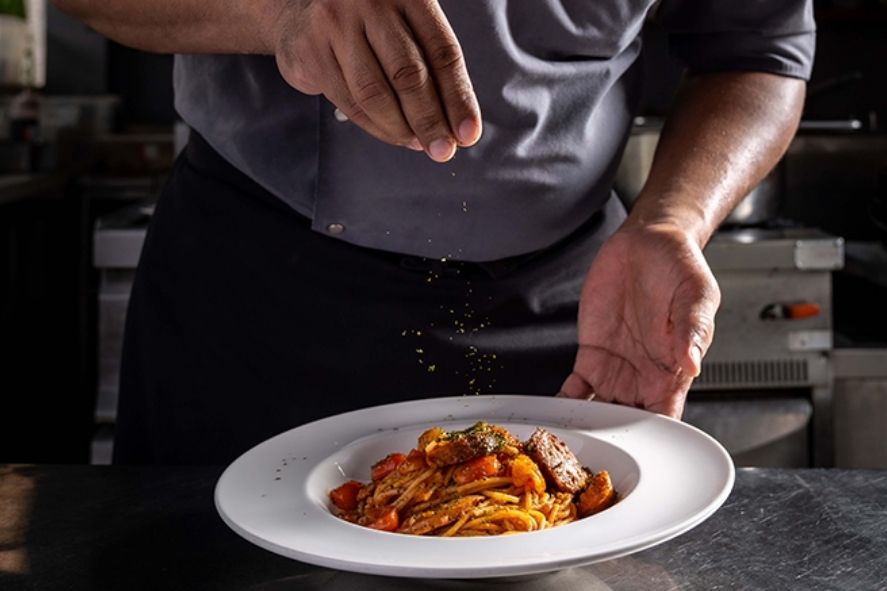 เชฟกำลังโรยเครื่องปรุงปิดท้ายบนจานพาสต้าที่ปรุงสดใหม่ที่ Terrazzo Ristorante